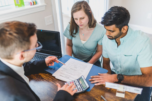 Three People Discussing Paperwork